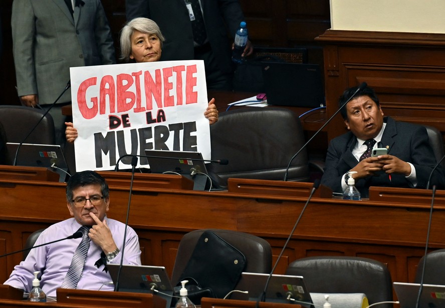 Deputada peruana segura placa com os dizeres 'Gabinete da Morte' durante sessão plenária do Congresso, em Lima