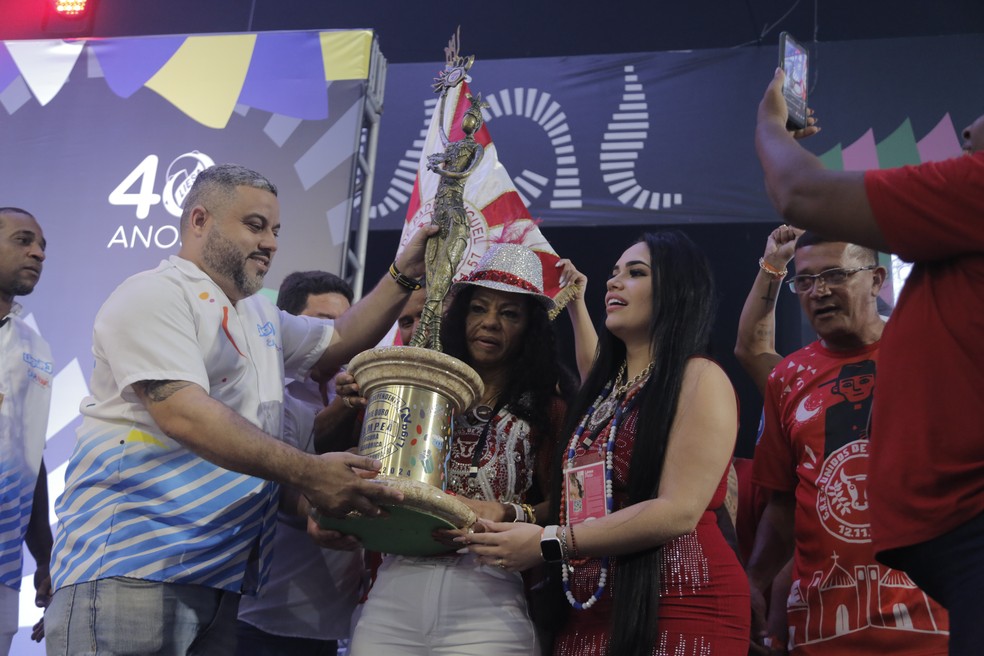 Lara Mara (à direita) com Deise Mara Rodrigues, esposa de Celsinho, e o troféu da Unidos de Padre Miguel — Foto: Fabio Rossi/Agência O Globo