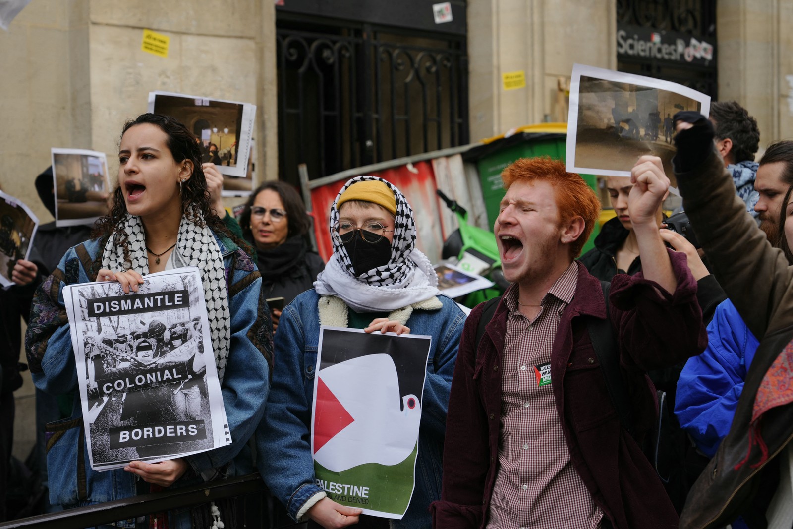 Manifestantes seguram cartazes com os dizeres "desmantelar fronteiras coloniais" enquanto estudantes ocupam um prédio do Instituto de Estudos Políticos em apoio aos palestinos, em Paris. — Foto: DIMITAR DILKOFF/AFP