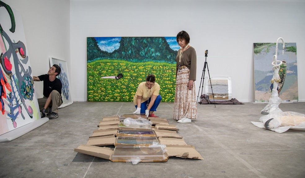 A galerista Anita Schwartz (de pé) escolhe posicionamento de obras no estande da galeria que leva o seu nome — Foto: Ana Branco
