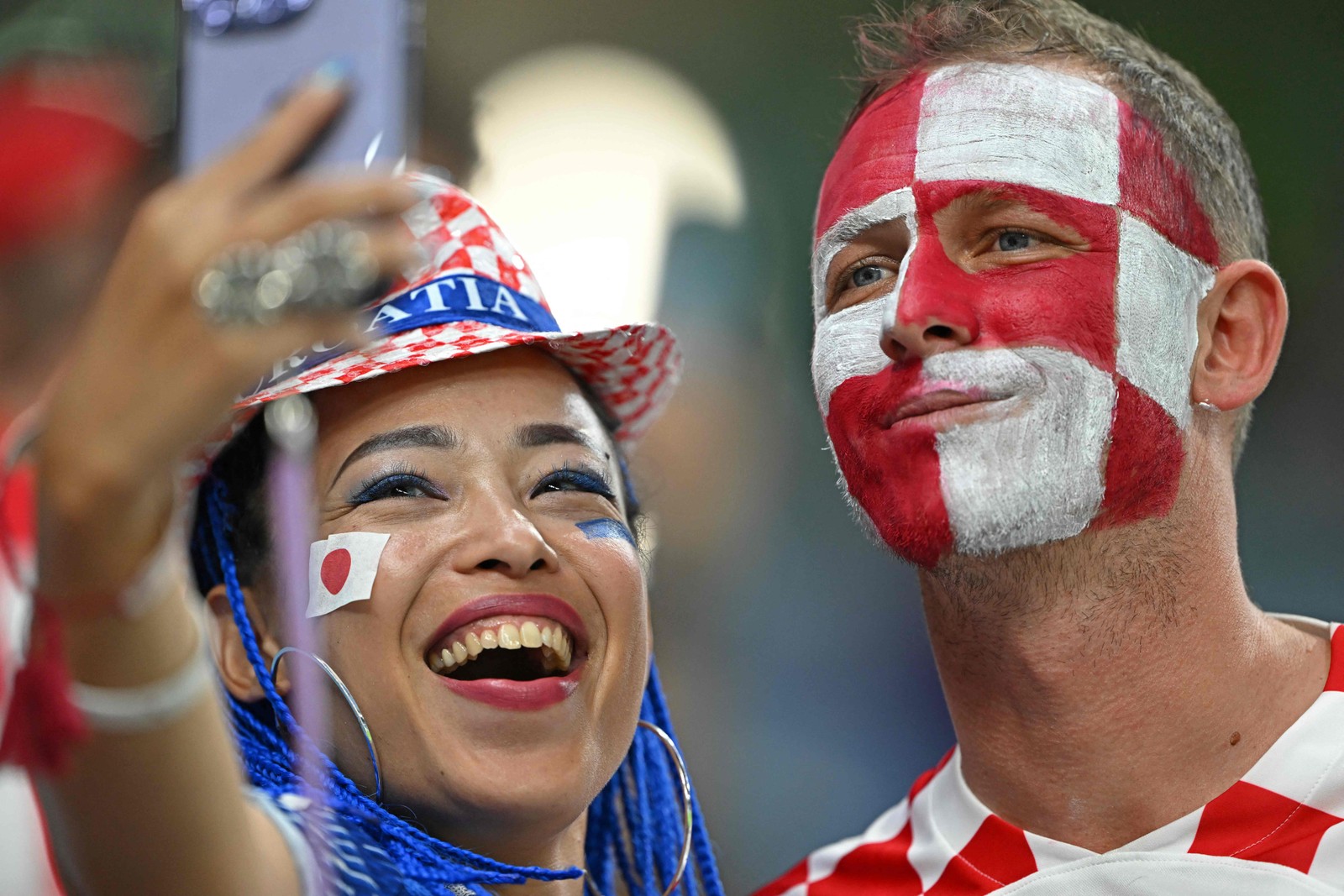 Torcedores rivais fazem selfie antes da partida Japão x Croácia — Foto: OZAN KOSE/AFP