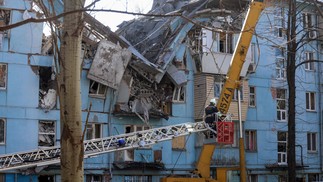 Equipes de resgate ucranianas em uma escada rolante trabalham em um prédio residencial de cinco andares destruído após um ataque com mísseis em Zaporizhzhia — Foto: KATERINA KLOCHKO/AFP