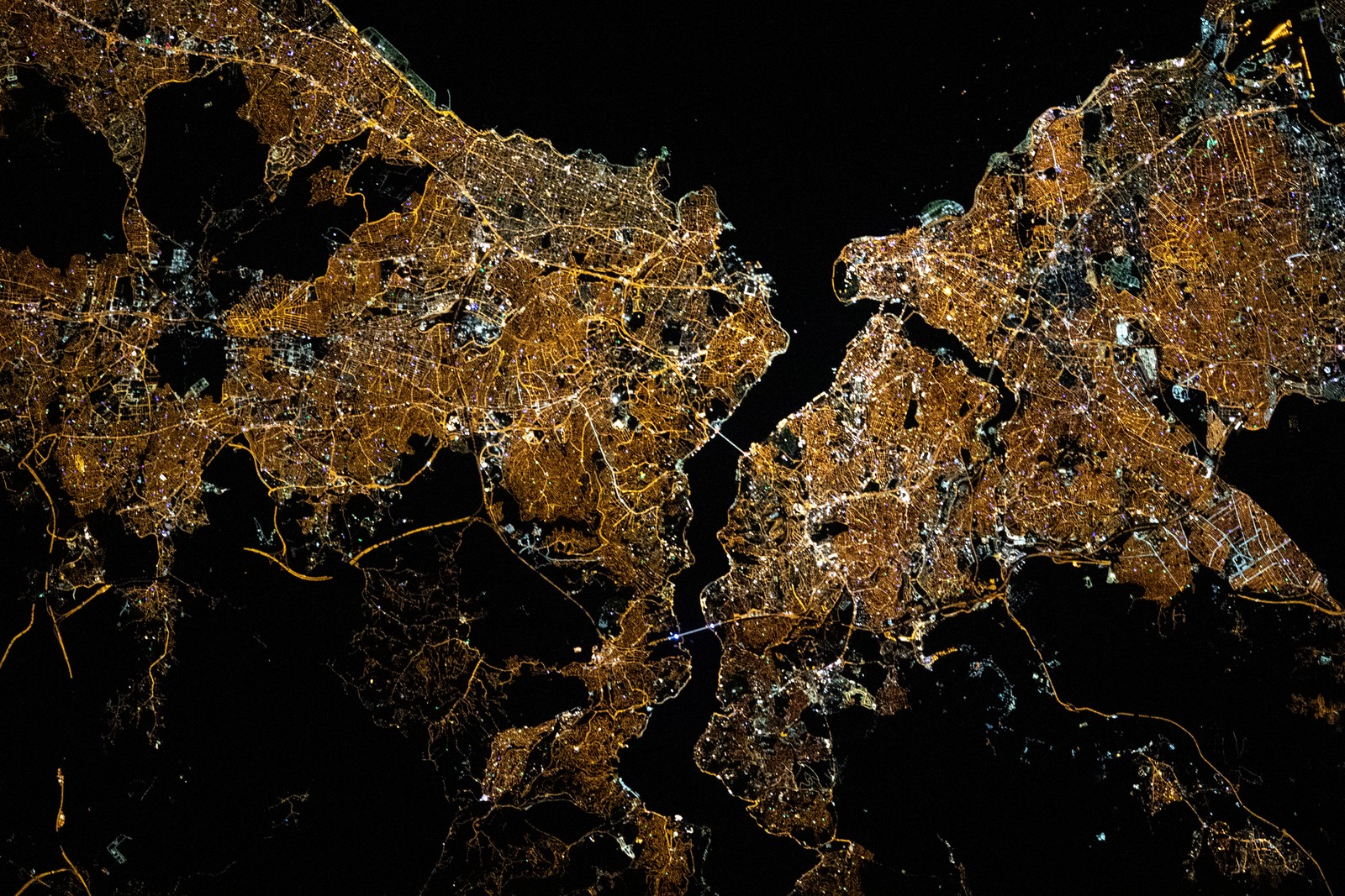 As luzes noturnas de Istambul, Turquia, divididas pelo Estreito de Bósforo e pelo Chifre de Ouro, são retratadas da Estação Espacial Internacional enquanto orbitava a cerca de 420 quilômetros acima do Mar Negro. Registro de 10 de maio de 2021