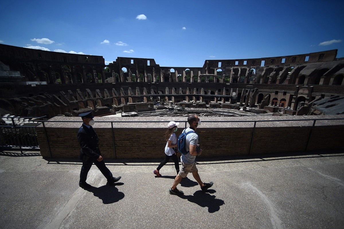 Visitantes seguidos por um segurança no Coliseu, em RomaAFP