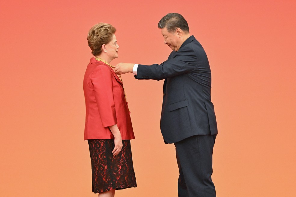 O presidente da China, Xi Jinping, entrega a Medalha da Amizade a Dilma Rousseff, presidente do Novo Banco de Desenvolvimento e ex-presidente do Brasil — Foto: ADEK BERRY / AFP