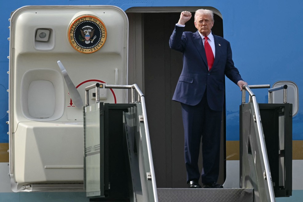 O presidente dos EUA, Donald Trump, ergue o punho antes de embarcar de volta aos EUA após encontro com o líder da China, Xi Jinping, na Coreia do Sul — Foto: ANDREW CABALLERO-REYNOLDS / AFP