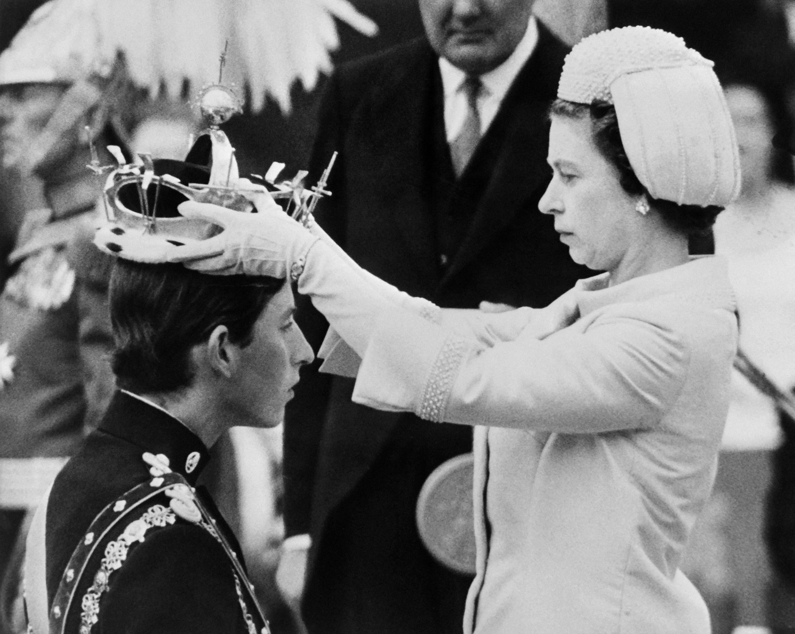 A rainha Elizabeth II coloca uma coroa em seu filho, o príncipe Charles, durante sua investidura como novo príncipe de Gales, em Caernarfon, em 1º de julho de 1969 — Foto: CENTRAL PRESS / AFP