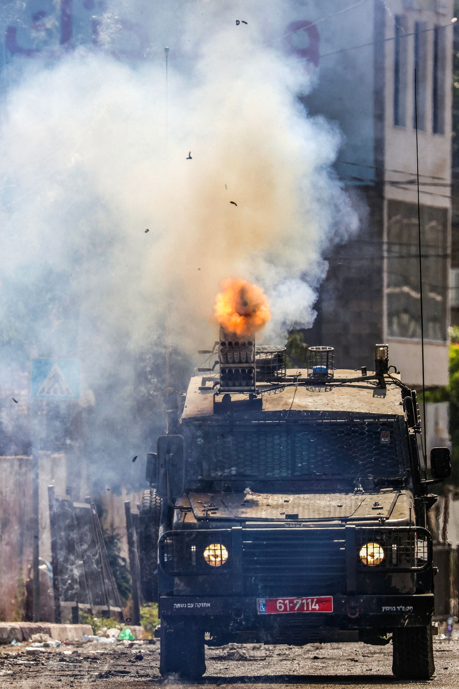 Soldados israelenses disparam bombas de gás lacrimogêneo de um veículo blindado durante uma operação militar em andamento na cidade ocupada de Jenin, na Cisjordânia, em 4 de julho de 2023. — Foto: Ronaldo SCHEMIDT / AFP