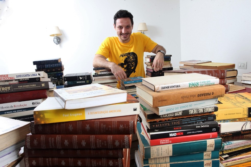 O jornalista Rodrigo Camarão con os livros doados para a Biblioteca Parque de Niterói  Divulgação — Foto:         