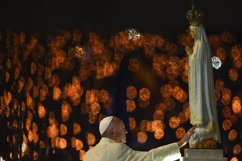 Papa Francisco toca figura que representa Nossa Senhora de Fátima no Santuário em Fátima, Portugal — Foto: PATRICIA DE MELO MOREIRA / AFP PHOTO
