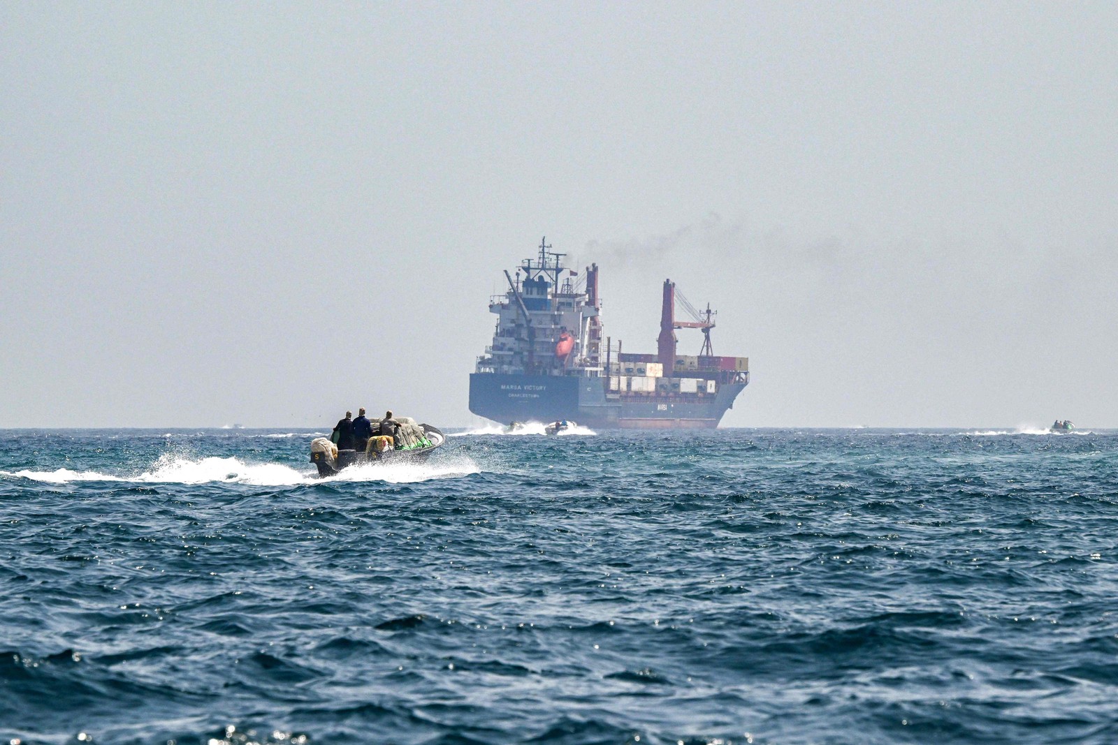 Lancha se aproxima de navio no Estreito de Ormuz — Foto: Giuseppe CACACE / AFP