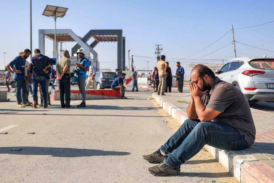 Homem reage enquanto está sentado perto do portão do posto de fronteira de Rafah com o Egito, no sul da Faixa de Gaza