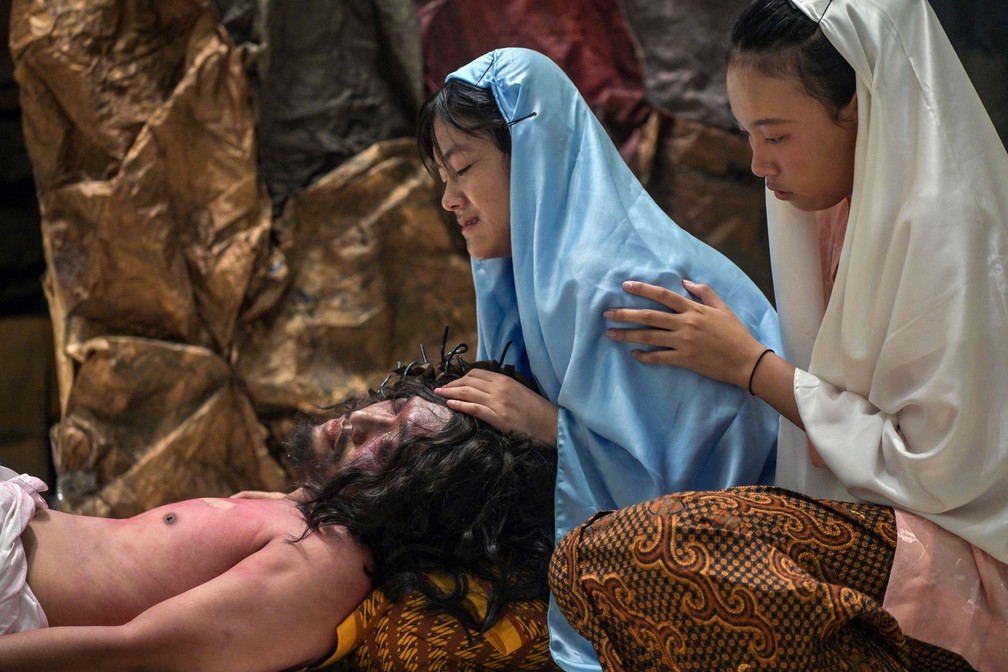 Católicos indonésios reencenam a crucificação de Jesus Cristo no complexo da igreja de São Vicente de Paulo em Surabaya, na ilha de Java oriental — Foto: Juni Kriswanto / AFP