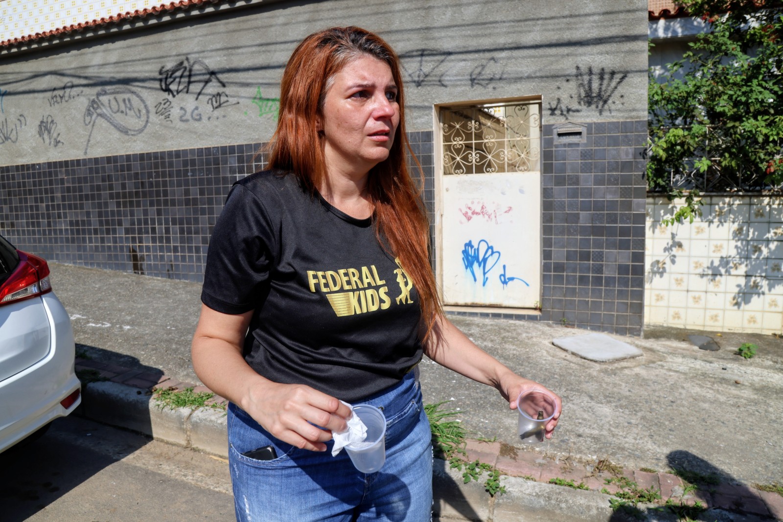 Na foto, Tais Oliveira segura as cápsulas que encontrou no local onde o irmão foi morto — Foto: Fabiano Rocha / Agência O Globo