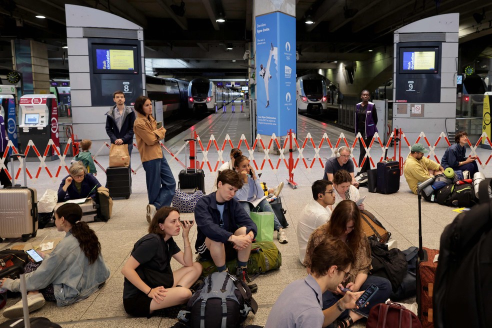 Avec le système de train rapide français touché, les passagers sont assis par terre dans la gare Montparnasse en attendant une solution ; Les problèmes devraient durer jusqu'au week-end — Photo: Thibaud Moritz / AFP