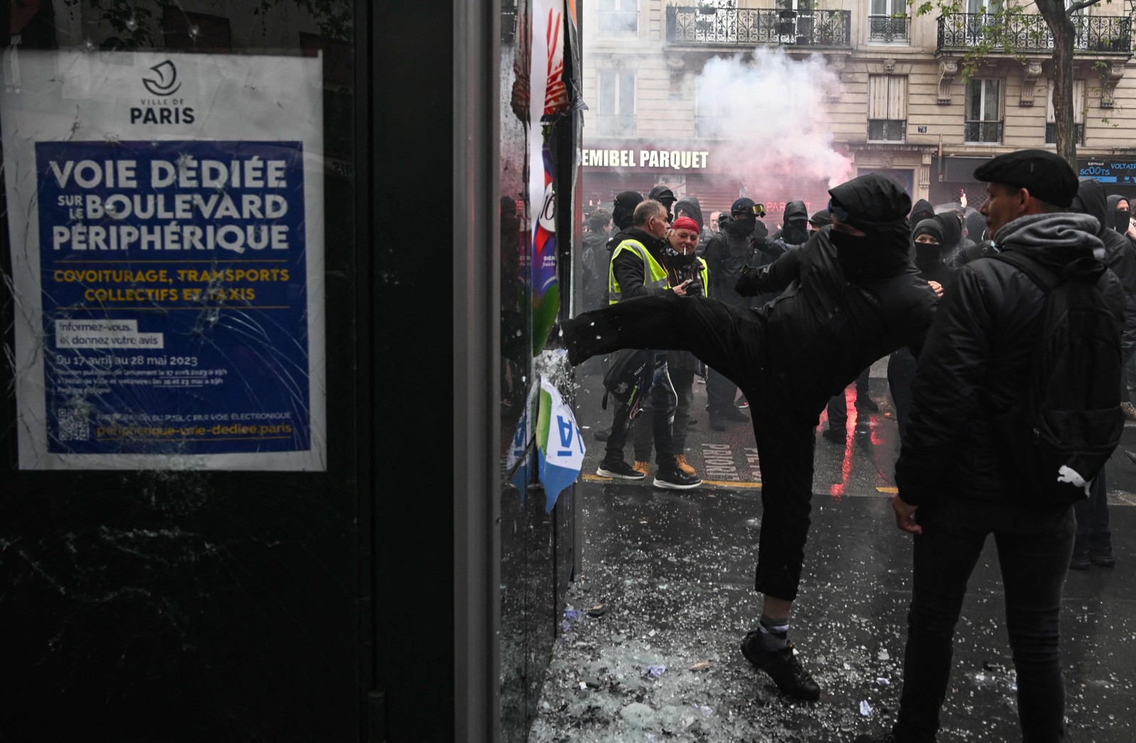 Manifestante quebra a vidraça de um quiosque durante ato para marcar o Dia Internacional dos Trabalhadores, em Paris — Foto:  Alain JOCARD / AFP