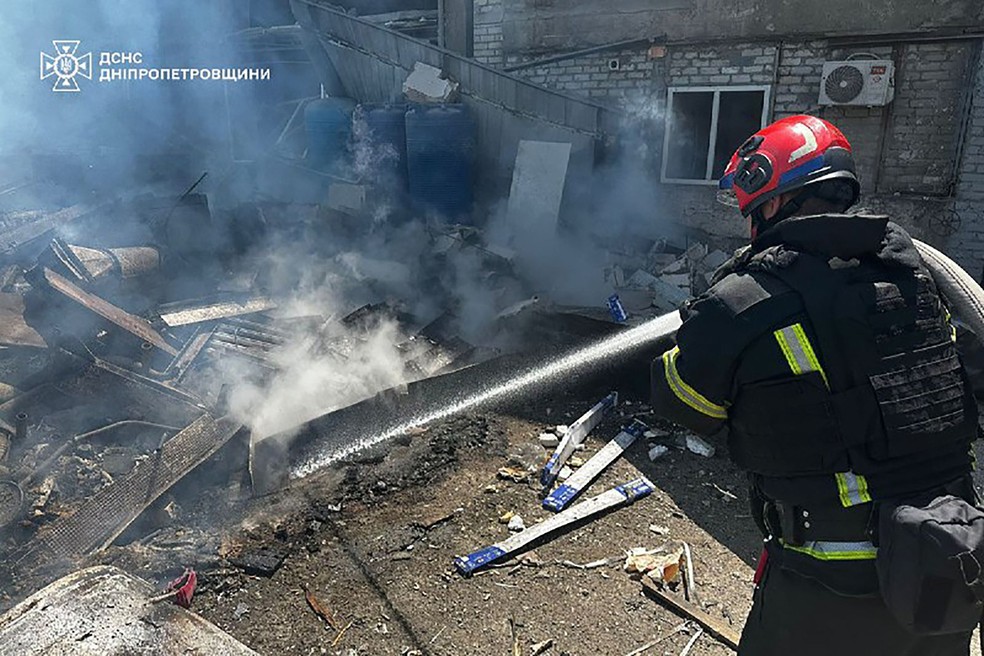 Bombeiros trabalham no combate a incêndio após ataque russo à cidade ucraniana de Dnipro — Foto: Serviço de Emergência da Ucrânia / AFP