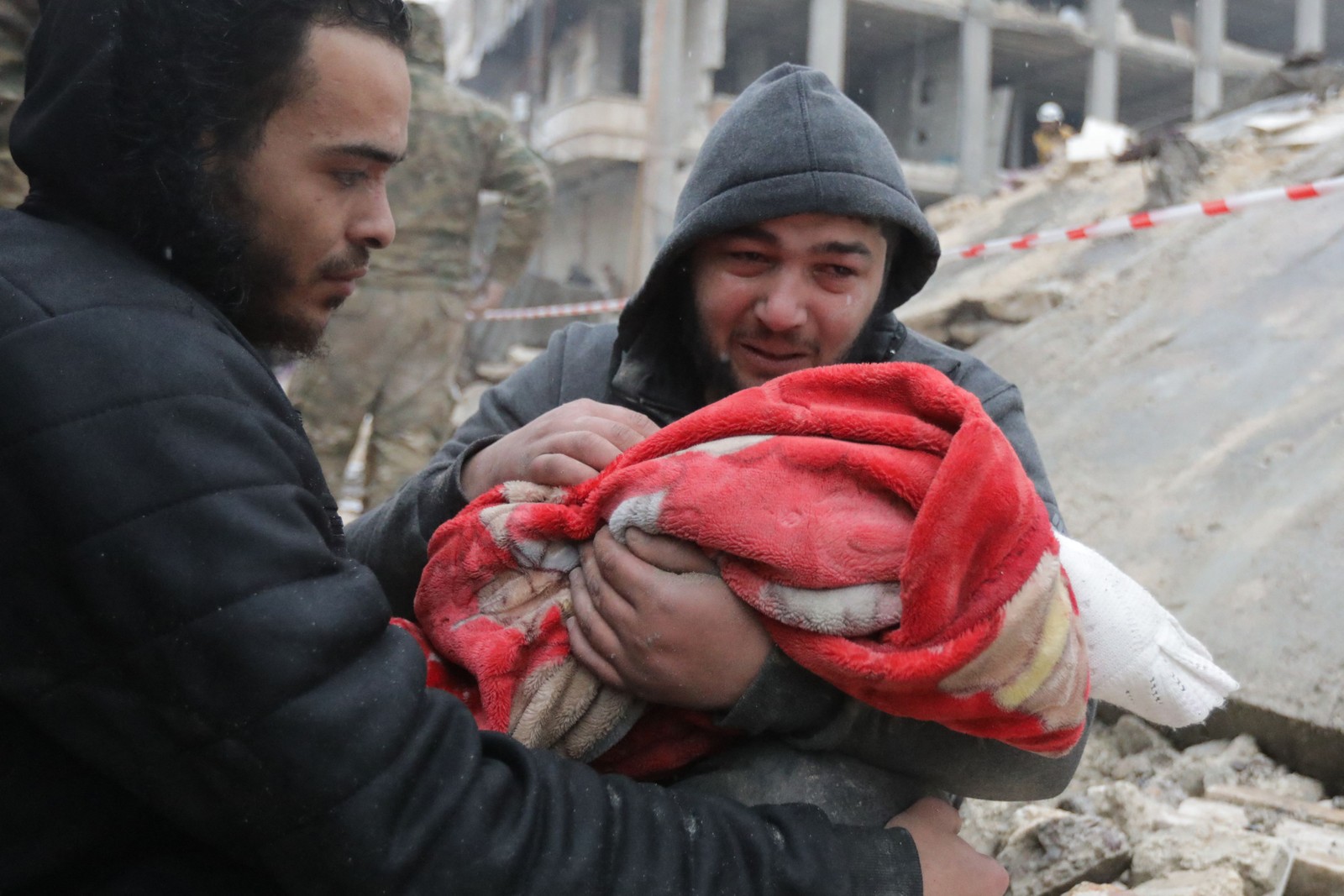 Homem chora enquanto carrega o corpo de seu filho, morto após terremoto no noroeste da Síria em 6 de fevereiro de 2023 — Foto: Bakr Alkasem / AFP