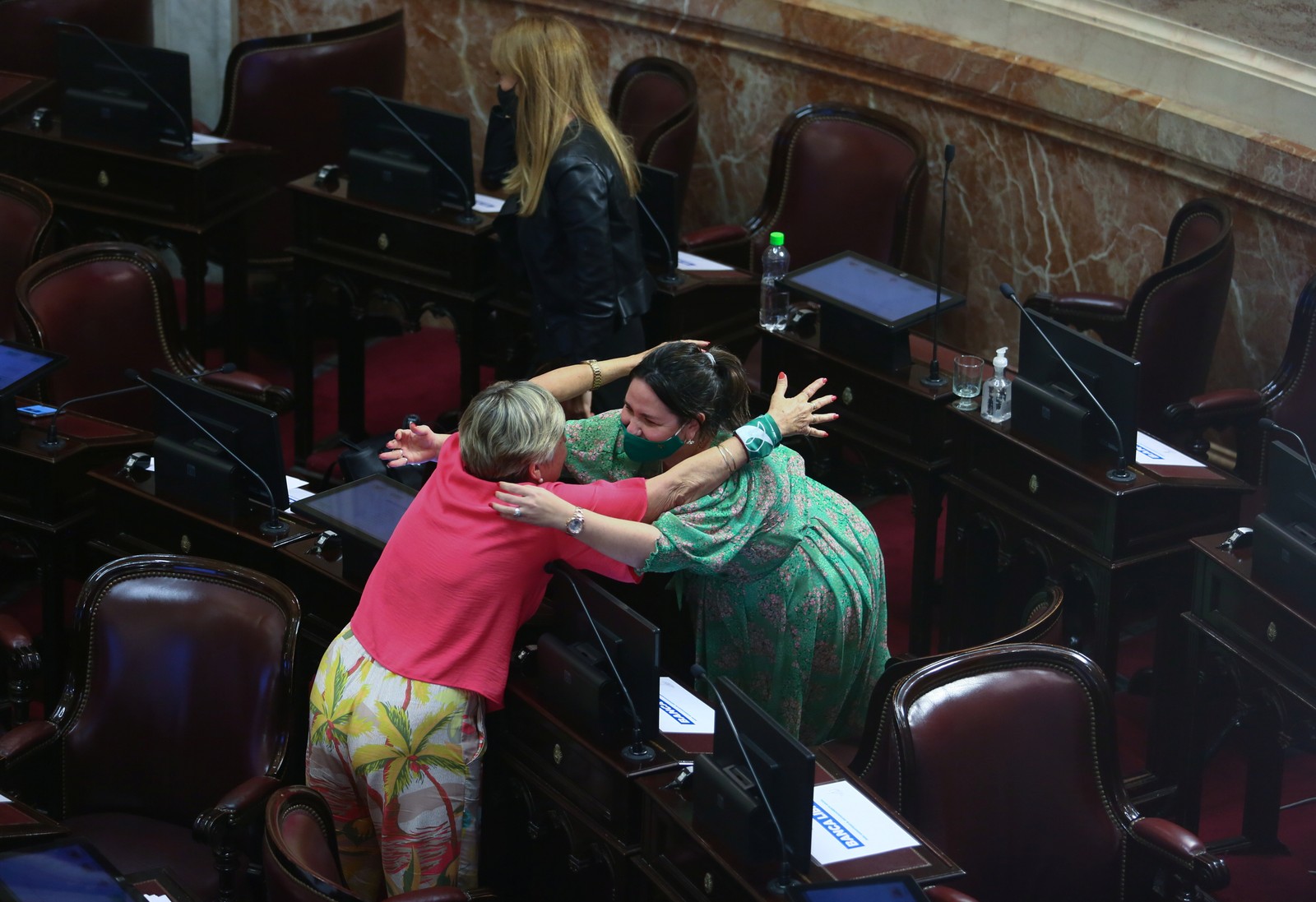 No Senado argentino, duas mulheres se abraçam para comemorar a aprovação da legalização do abortoREUTERS