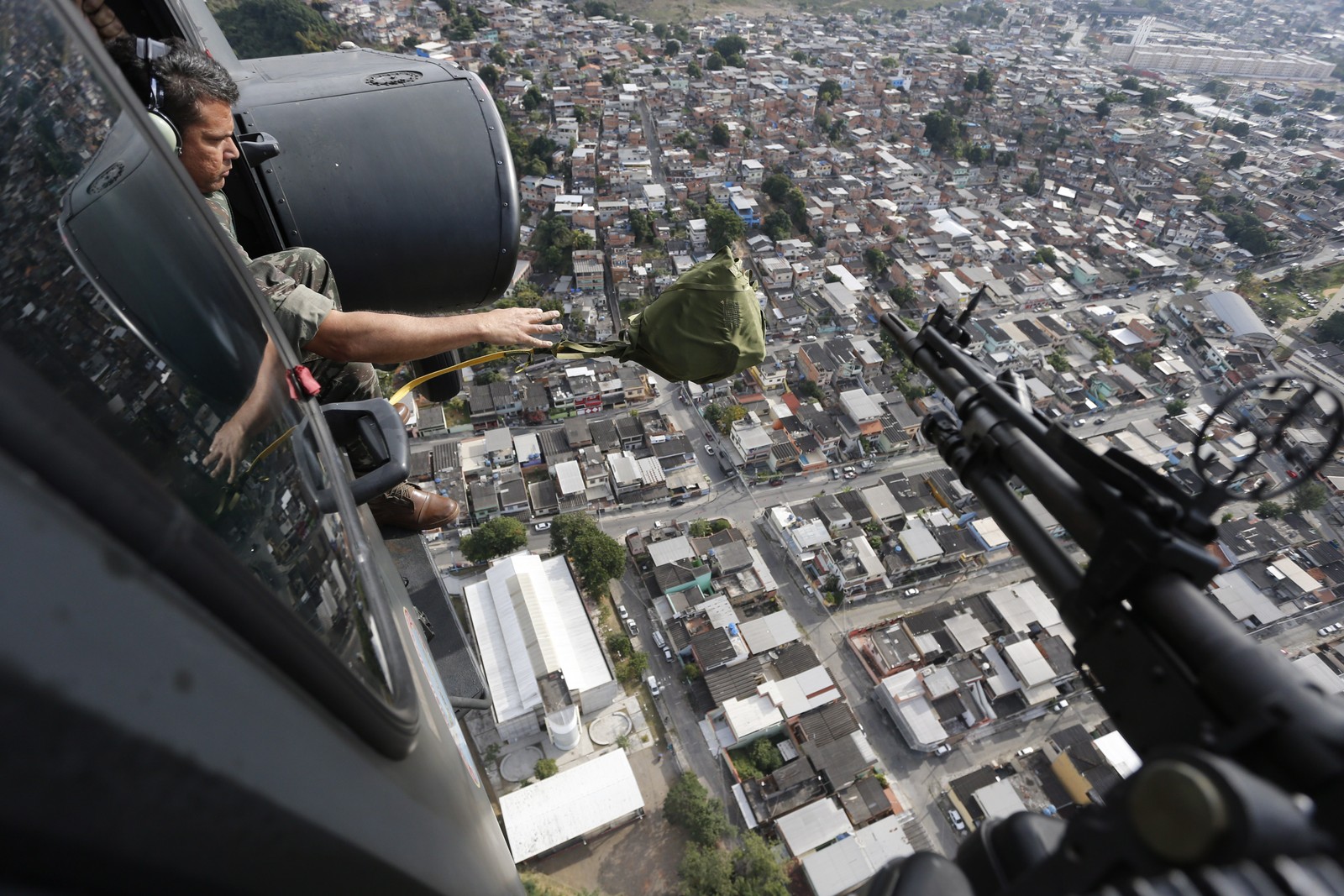 Helicóptero do Exército Brasileiro sobrevoa o Complexo do Chapadão jogando panfletos — Foto: Domingos Peixoto / Agência O Globo
