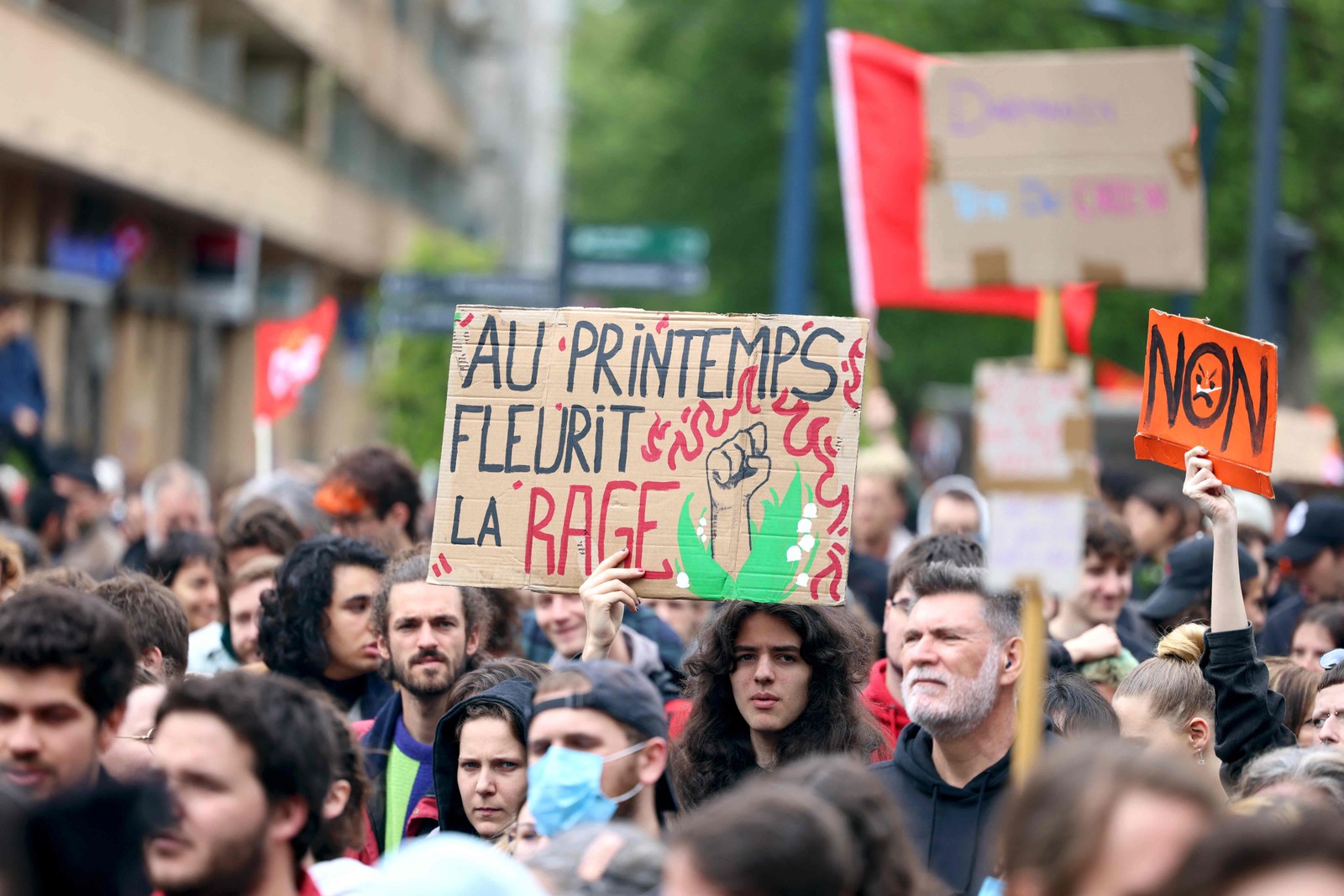 Manifestante exibe cartaz com a frase "Na primavera a raiva floresce", durante marcha pelo Primeiro de Maio, em Toulouse, sudoeste da França — Foto: CHARLY TRIBALLEAU / AFP