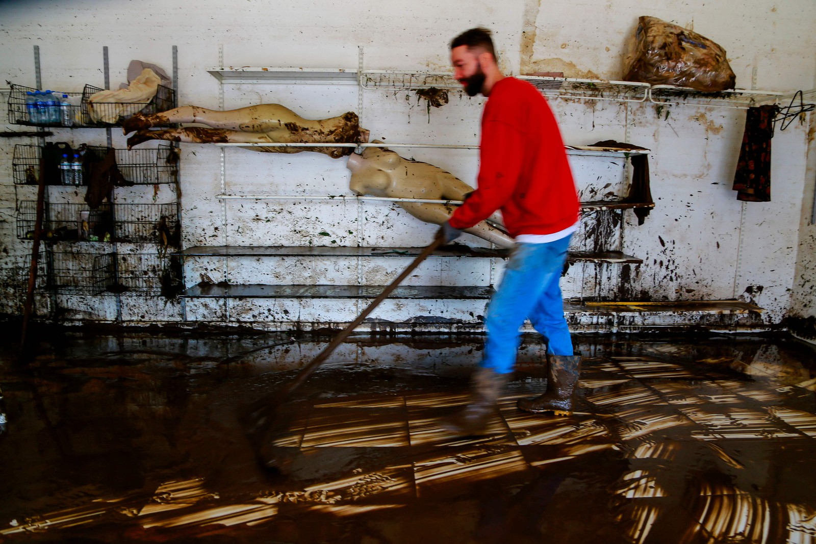 Um homem limpa o interior de uma loja após um ciclone em Muçum, Rio Grande do Sul, Brasil — Foto: SILVIO ÁVILA/AFP