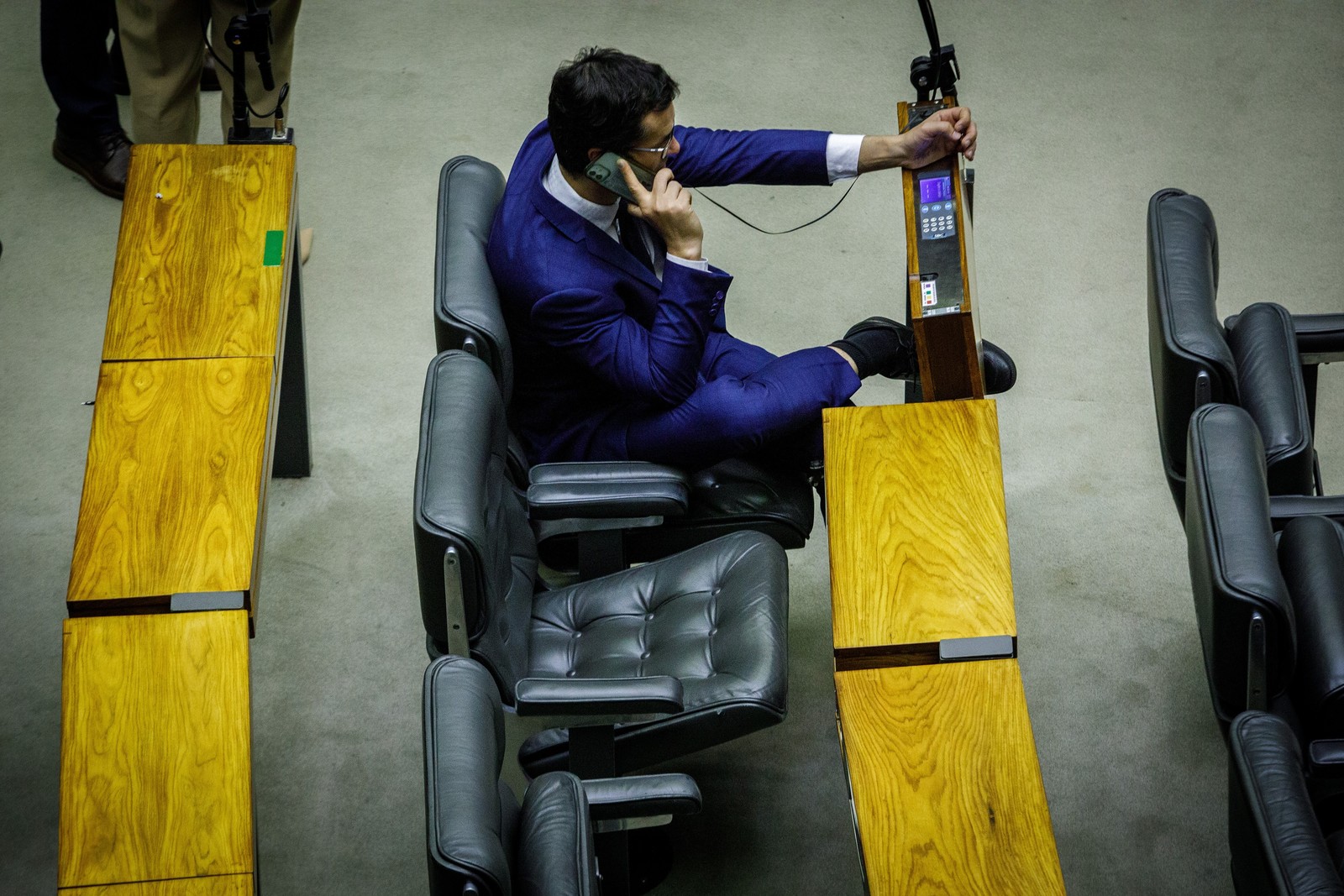 Deltan fala ao telefone enquanto carrega o aparelho — Brenno Carvalho/ Agência O Globo — Foto: Brenno Carvalho/ Agência O Globo