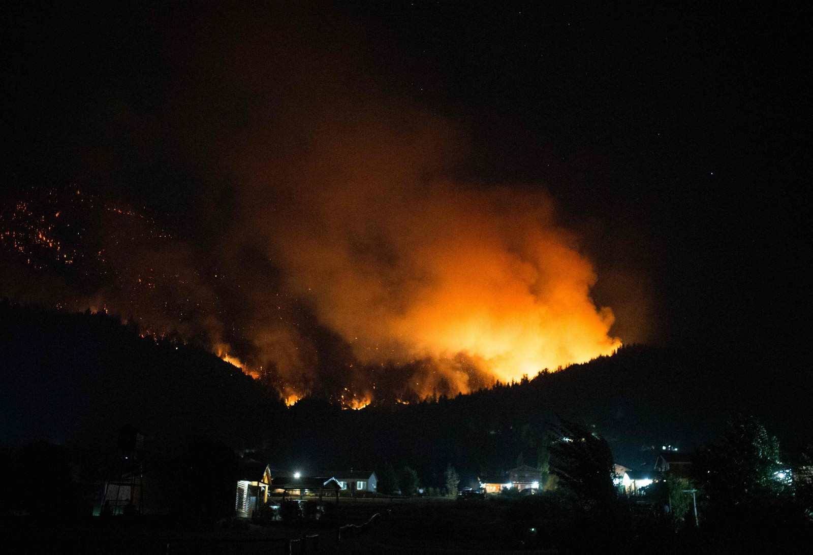 Centenas de bombeiros combatem o incêndio com o apoio de helicópteros e seis aviões-tanque — Foto: Martin Levicoy/AFP