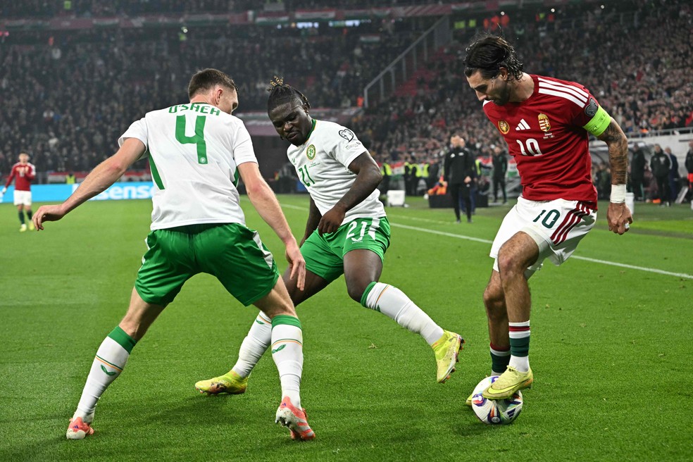 Meia Dominik Szoboszlai controlando a bola enquanto é cercado pro defensores da Irlanda — Foto: Attila KISBENEDEK / AFP