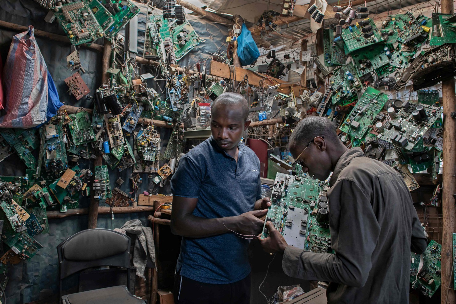 David Gathu e Moses Kiuna em sua oficina em Nairóbi — Foto: Tony KARUMBA / AFP
