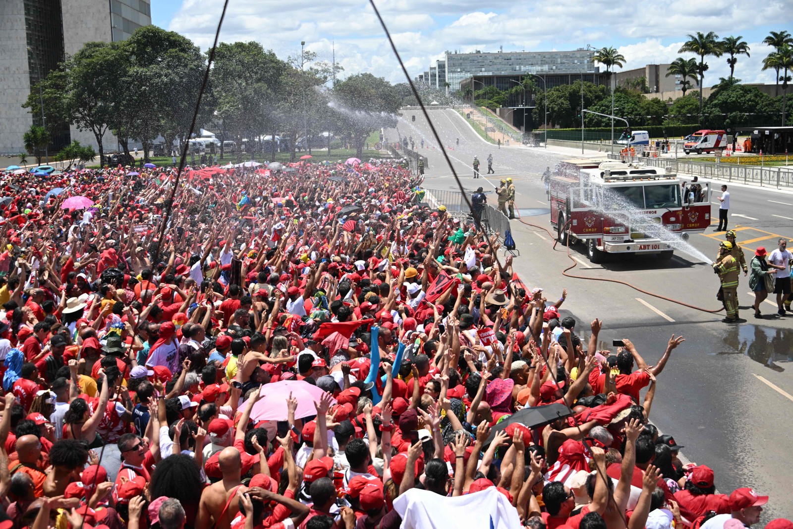 Bombeiros refrescam apoiadores de Lula, o novo presidente do Brasil — Foto: EVARISTO SA/AFP