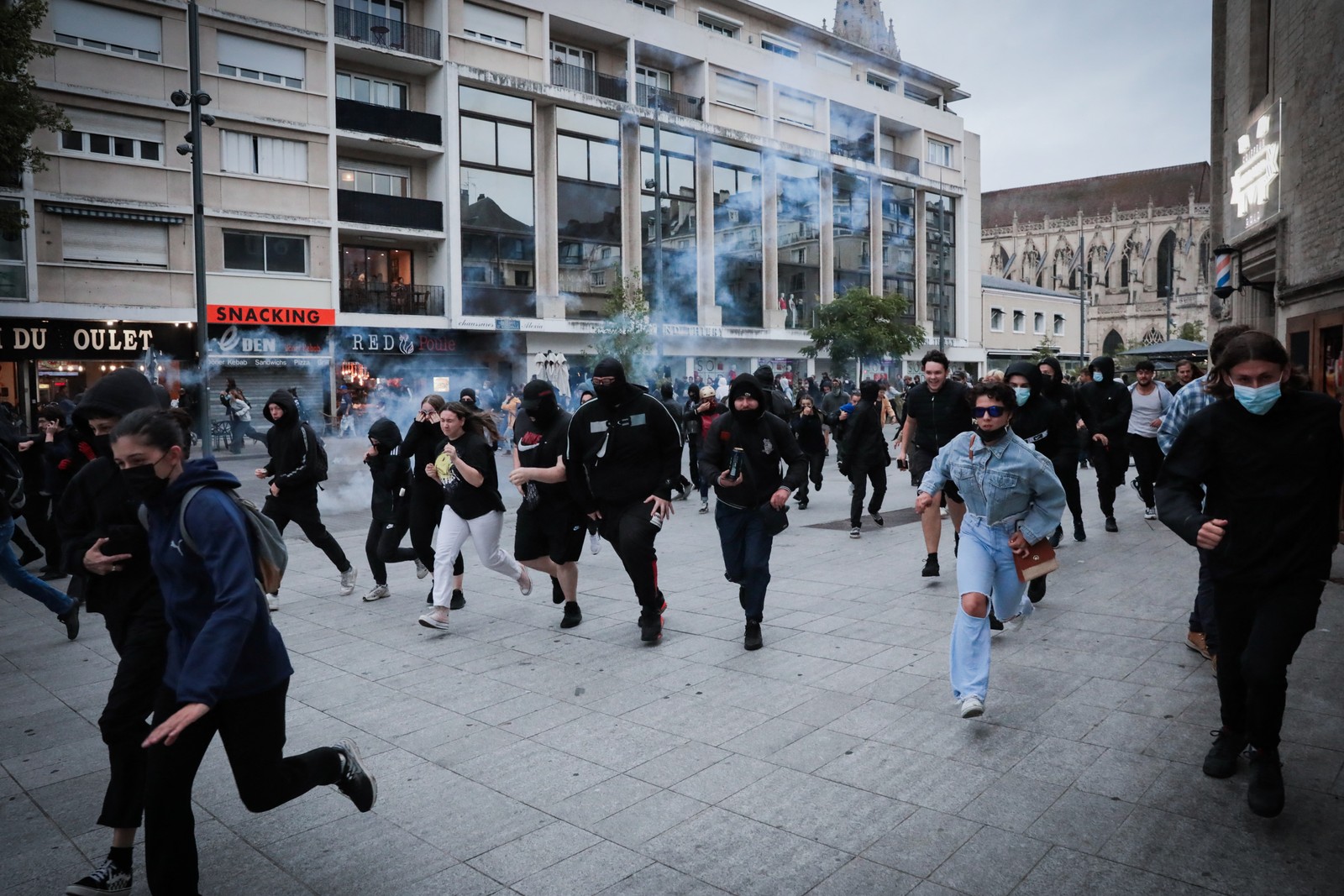 Manifestantes fogem de bombas de gás lacrimogêneo lançadas durante uma manifestação em Caen, noroeste da França, em 30 de junho de 2023 — Foto: LOU BENOIST / AFP