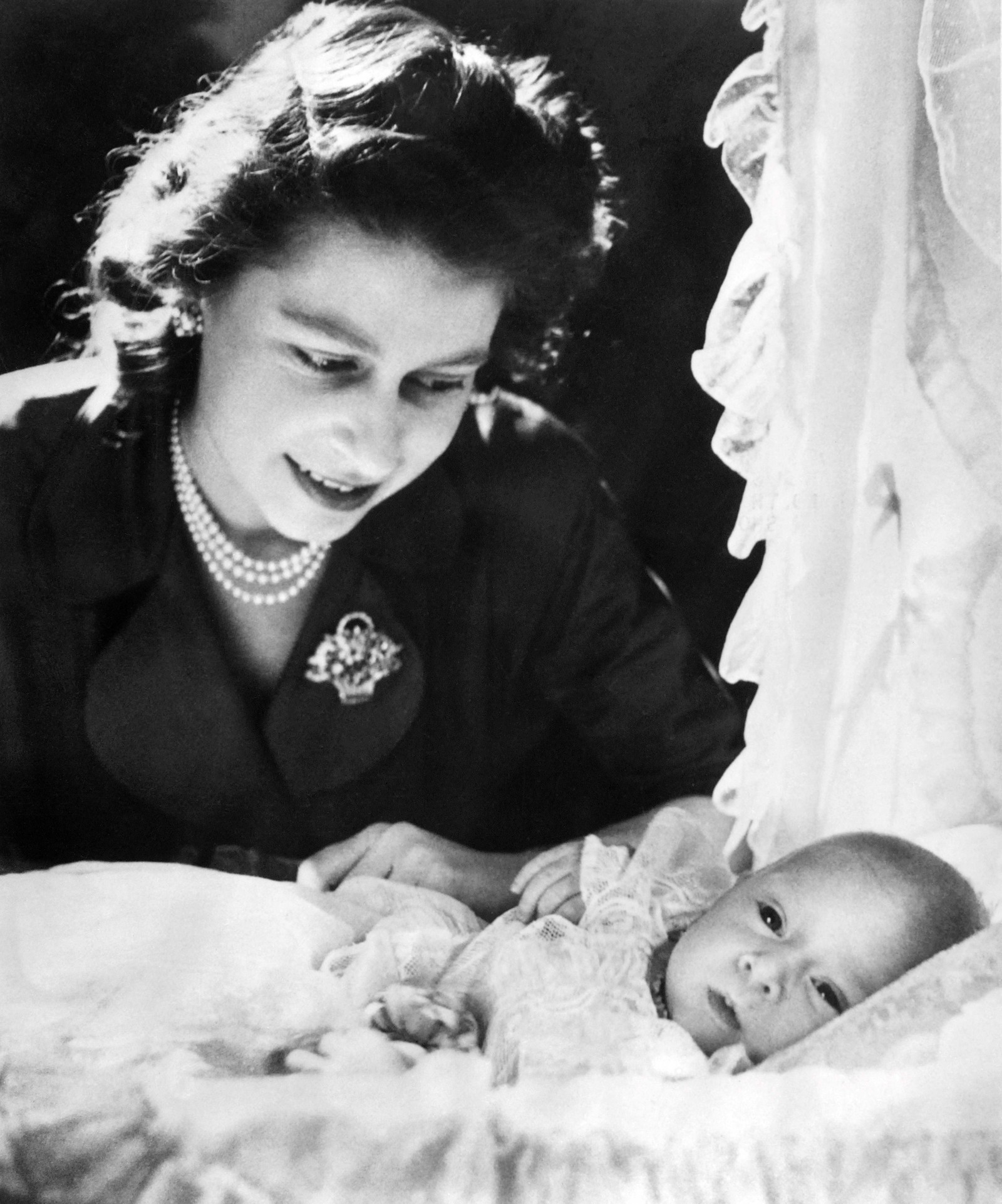 O príncipe Charles recém-nascido, observado pela mãe, a então princesa Elizabeth, em janeiro de 1949 — Foto: AFP