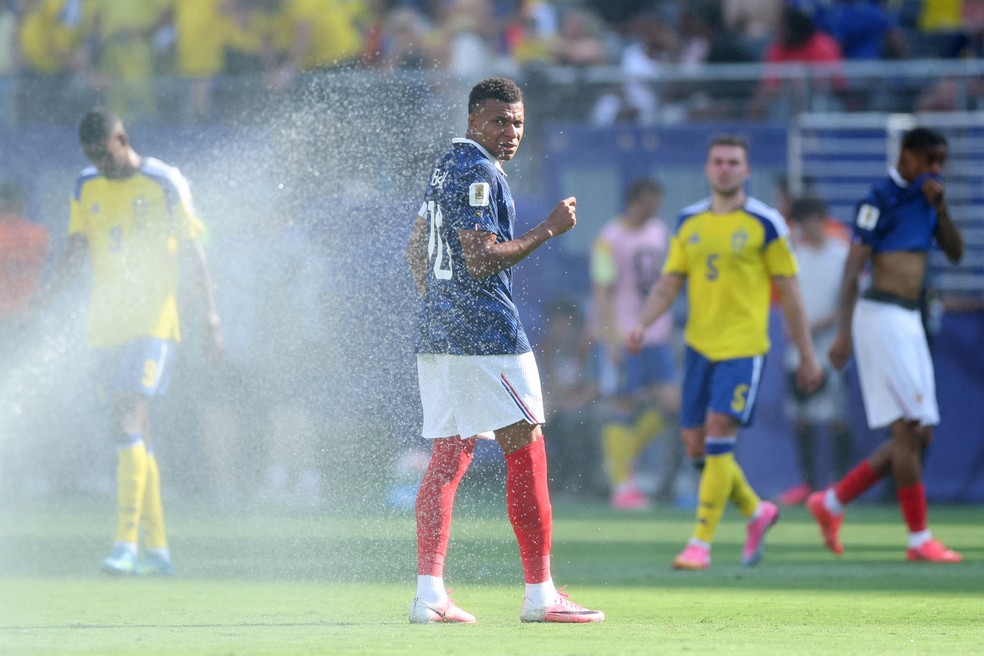 Kylian Mbappé é atingido por jato de água durante volta da pausa para hidratação em partida contra Suécia — Foto: Dan Mullan/Getty Images/AFP