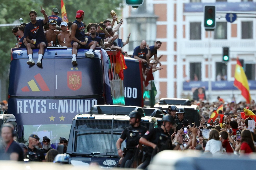 Os jogadores da Espanha desfilam em um ônibus aberto pelas ruas de Madri, em 20 de julho de 2026, um dia após a seleção conquistar seu segundo título da Copa do Mundo com a vitória por 1 a 0 sobre a Argentina.  Os campeões mundiais retornaram à capital espanhola para uma recepção de heróis, onde cerca de um milhão de torcedores eram esperados para saudá-los após uma noite de intensas comemorações por todo o país — Foto: Thomas COEX / AFP