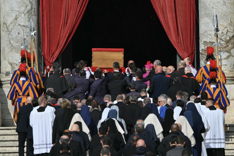 Carregadores, ao lado de guardas suíços, carregam o caixão do Papa Francisco durante o transporte da capela de Santa Marta para a Basílica de São Pedro — Foto: AFP