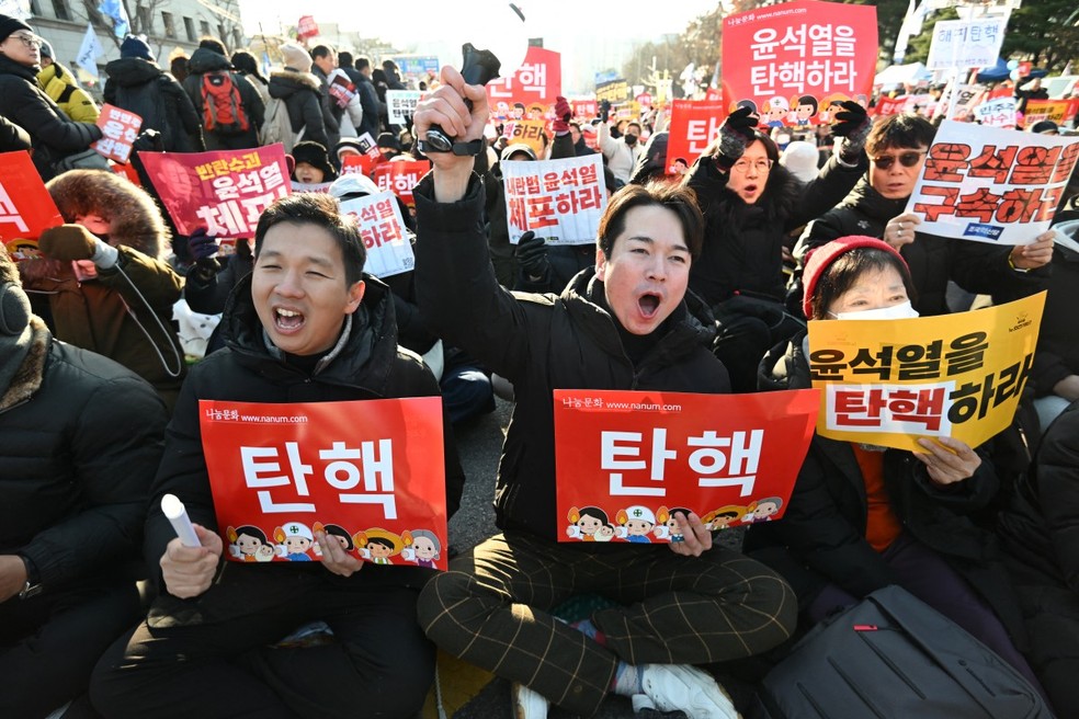 Pessoas gritam slogans enquanto participam de um protesto pedindo a deposição do presidente da Coreia do Sul — Foto: JUNG YEON-JE/AFP