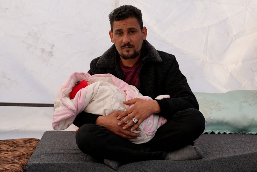 Khalil al-Suwadi segura sua sobrinha Afraa, um bebê sírio nascido sob os escombros após o terremoto de 6 de fevereiro que atingiu a Turquia e a Síria e matou seus pais e irmãos