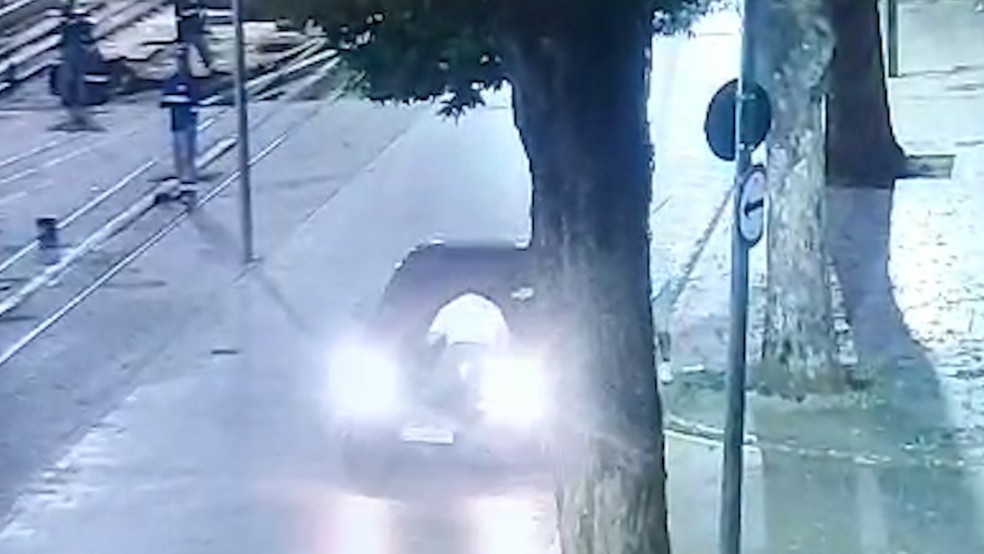 O turista mexicano sobre o capô do carro dos suspeitos — Foto: Reprodução