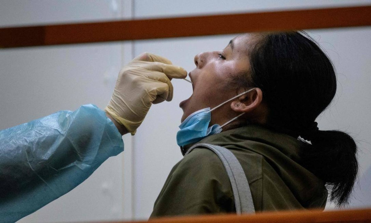 Residente passa por teste obrigatório de coronavírus, no distrito de Yau Tsim Mong de Kowloon, em Hong Kong, onde a China tenta controlar surto da Covid-19 na periferia densamente povoada — Foto: ANTHONY WALLACE / AFP