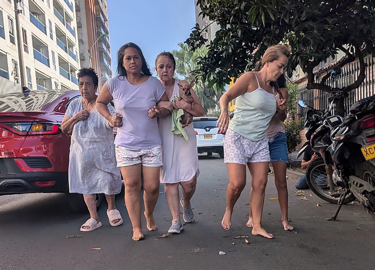 Moradoras de Cali caminham pelas ruas depois de deixarem suas casas por causa do terremoto que atingiu a Colômbia — Foto: JOAQUIN SARMIENTO/AFP