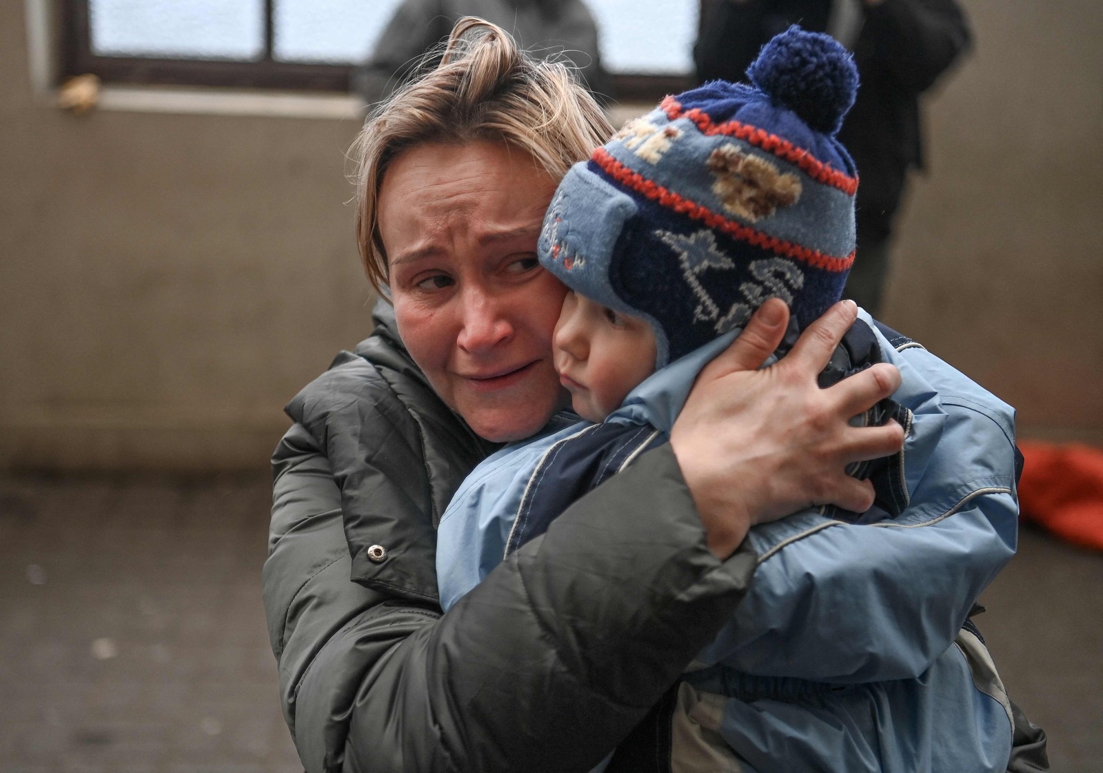 Mulher segura seu filho enquanto ela tenta embarcar em um trem gratuito para a Polônia em uma estação de trem em Lviv, oeste da Ucrânia — Foto: DANIEL LEAL / AFP