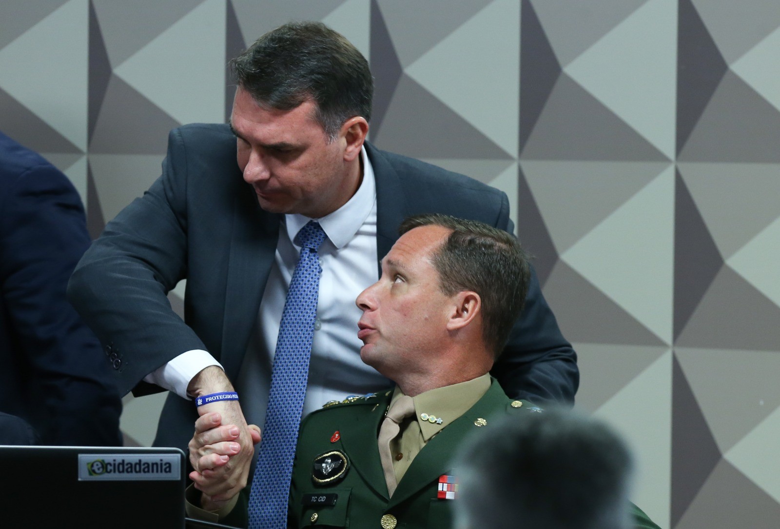 Flávio Bolsonaro cumprimenta Mauro Cid em depoimento na CPI do 8 de janeiro — Foto: Lula Marques/ Agência Brasil