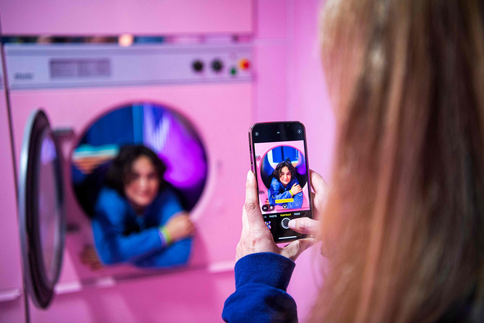 Pessoas visitam a "laundry room" e tiram fotos dentro das máquinas de lavar, no Youseum, em Solna, perto de EstocolmoAFP