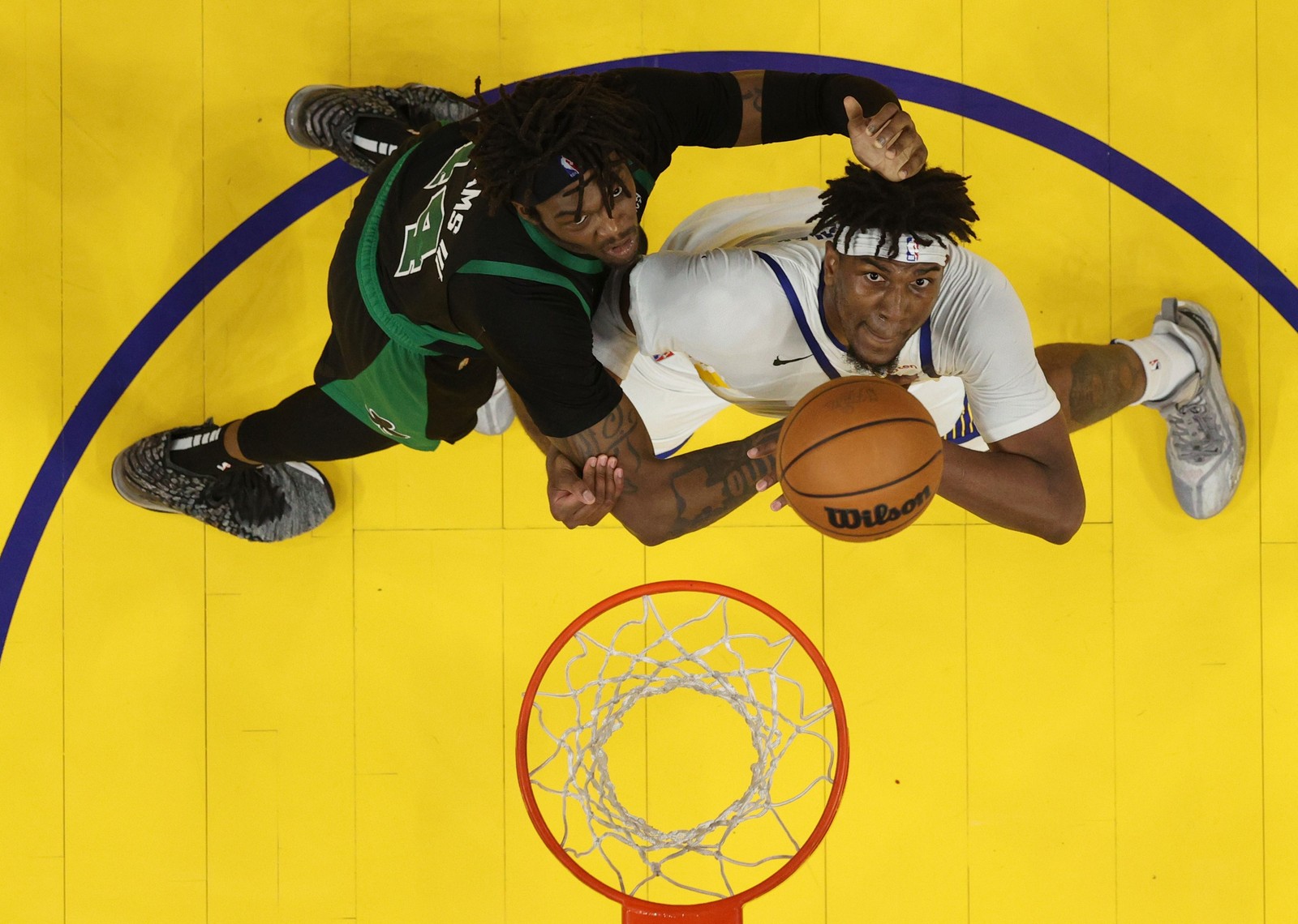 Kevon Looney, do Golden State Warriors, e Robert Williams, do Boston Celtics, competem pelo rebote. — Foto:  Ezra Shaw/Getty Images/AFP