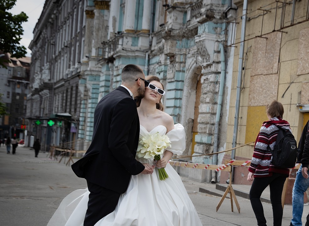 Casal tira fotos em rua de Kharkiv — Foto: Tyler Hicks/The New York Times