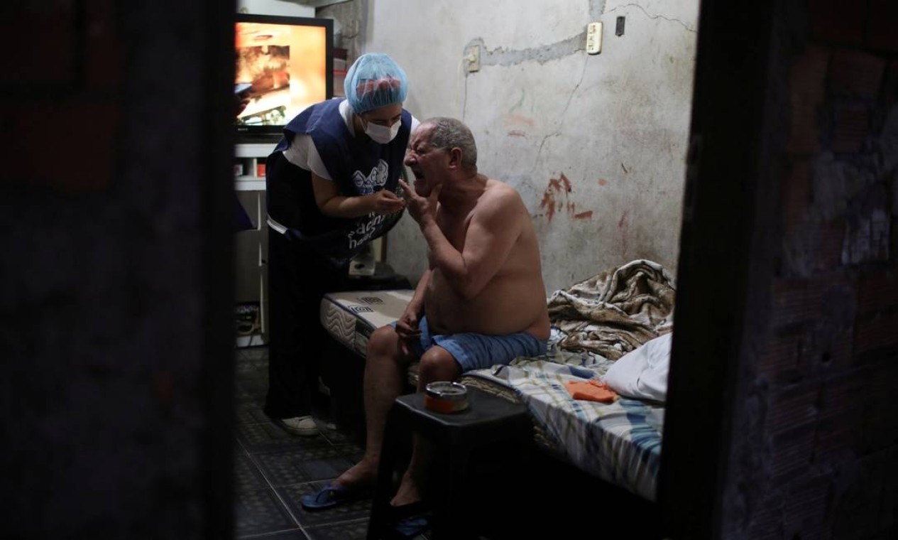 Carlos Alberto Tabares de Oliveira, 64 anos, recebe em casa a vacina da AstraZeneca contra Covid-19, na favela da Rocinha, Zona Sul do Rio — Foto: Pilar Olivares / Reuters