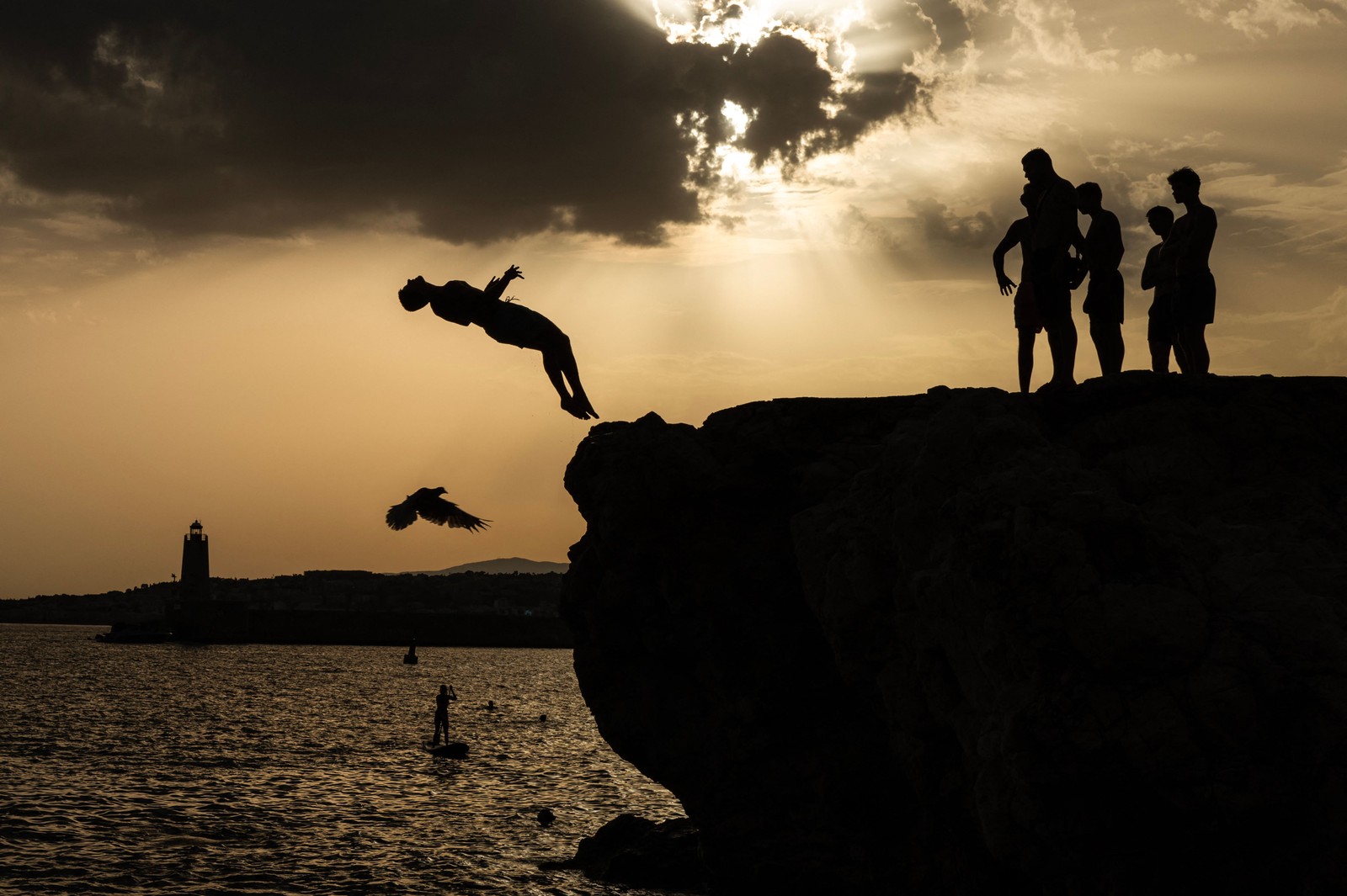 Jovens mergulham no mar Mediterrâneo na cidade de Nice, na Riviera Francesa, em 10 de agosto de 2023. — Foto: Valery HACHE / AFP