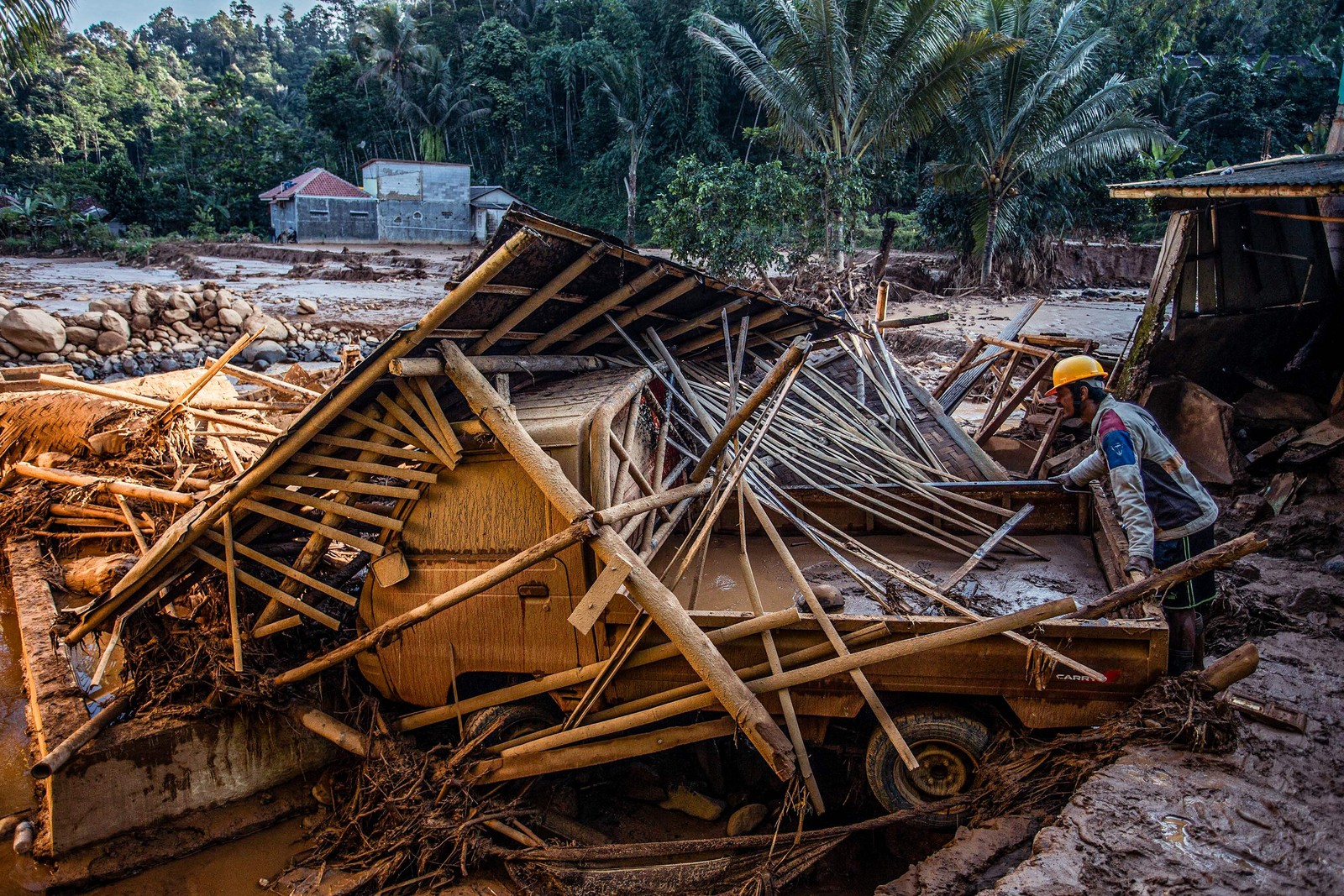 Equipe de resgate procura pessoas nos escombros de casas danificadas após uma inundação provocada por fortes chuvas atingir áreas residenciais na vila de Purasari, em Bogor, Indonésia — Foto: ADITYA AJI / AFP