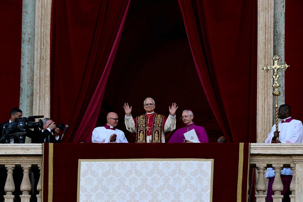 Papa Leão XIV acena para os fiéis no balcão diante da Praça de São Pedro — Foto: Tiziana FABI / AFP